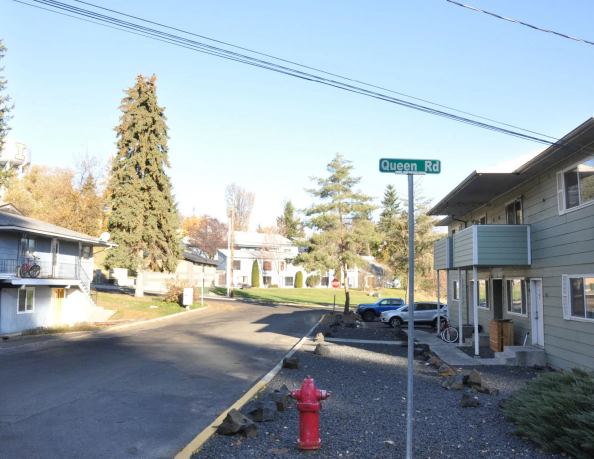 Residential street with a Queen Rd sign, red fire hydrant and apartment buildings.