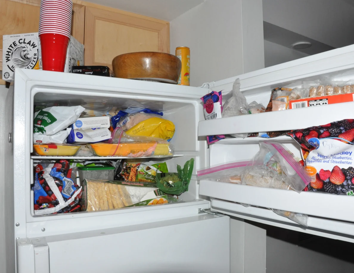 Open freezer stocked with bags, boxes and wrapped frozen foods.