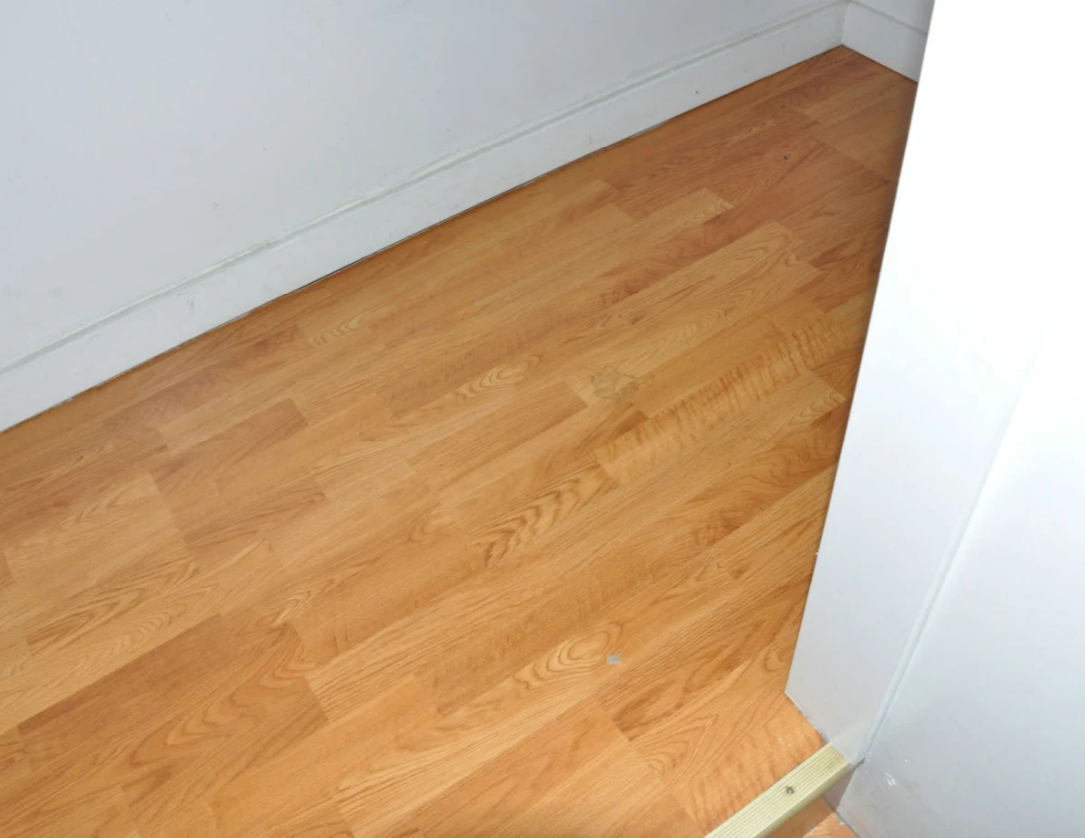Wooden landing beside a white wall and doorway trim.