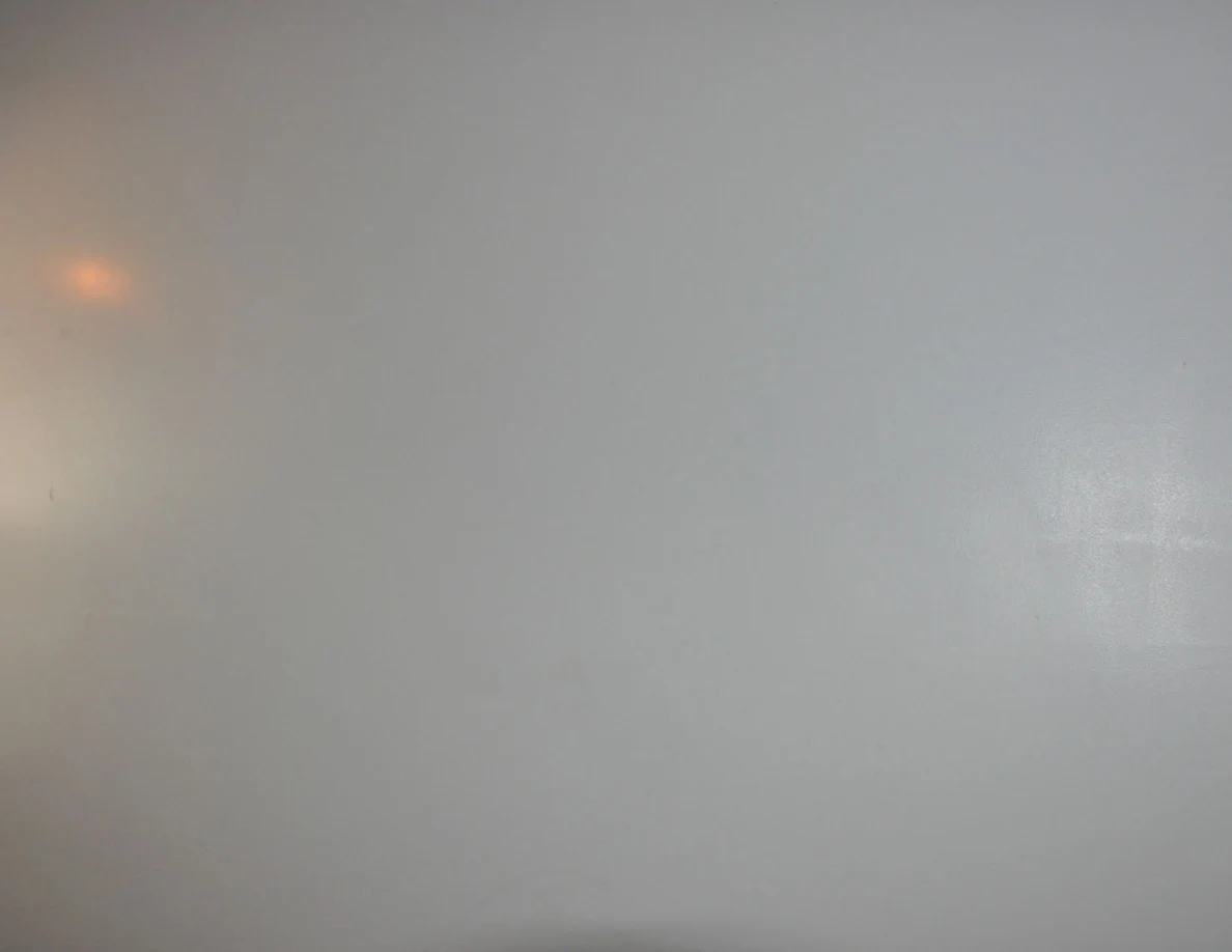 Plain white stairwell wall with reflected orange light.