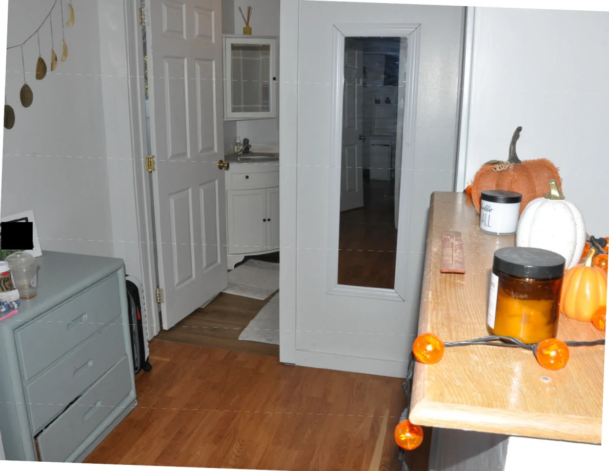 Landing with mirror, open bathroom door and decorative pumpkins and candles on a ledge.