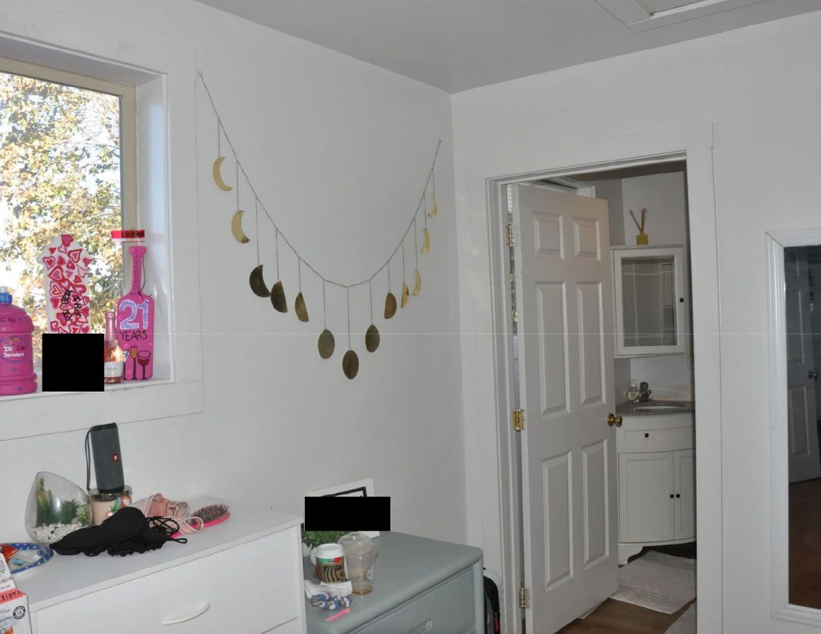Moon-phase garland above drawers beside an open bathroom door and window.