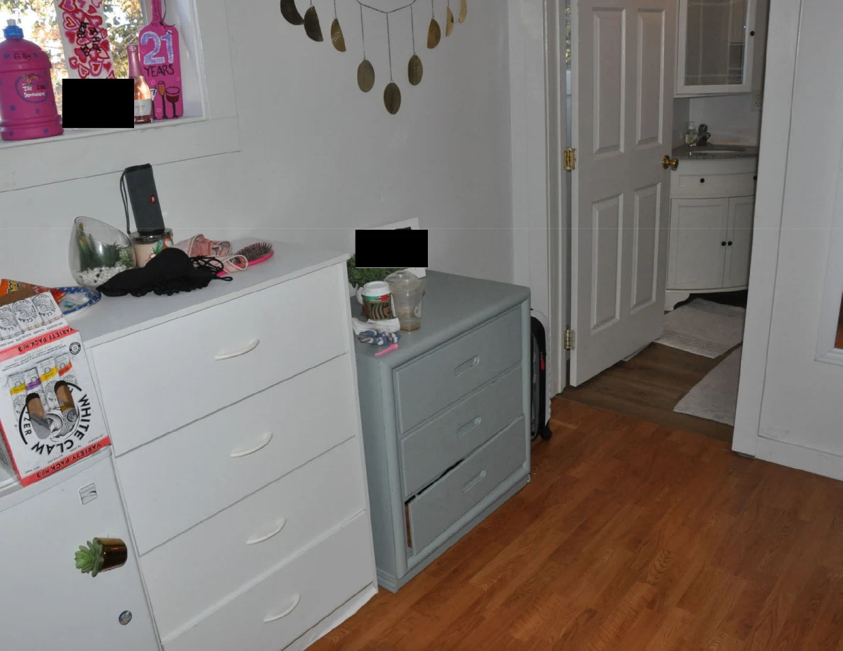 White and gray drawer units beside an open bathroom doorway on a wood-floored landing.