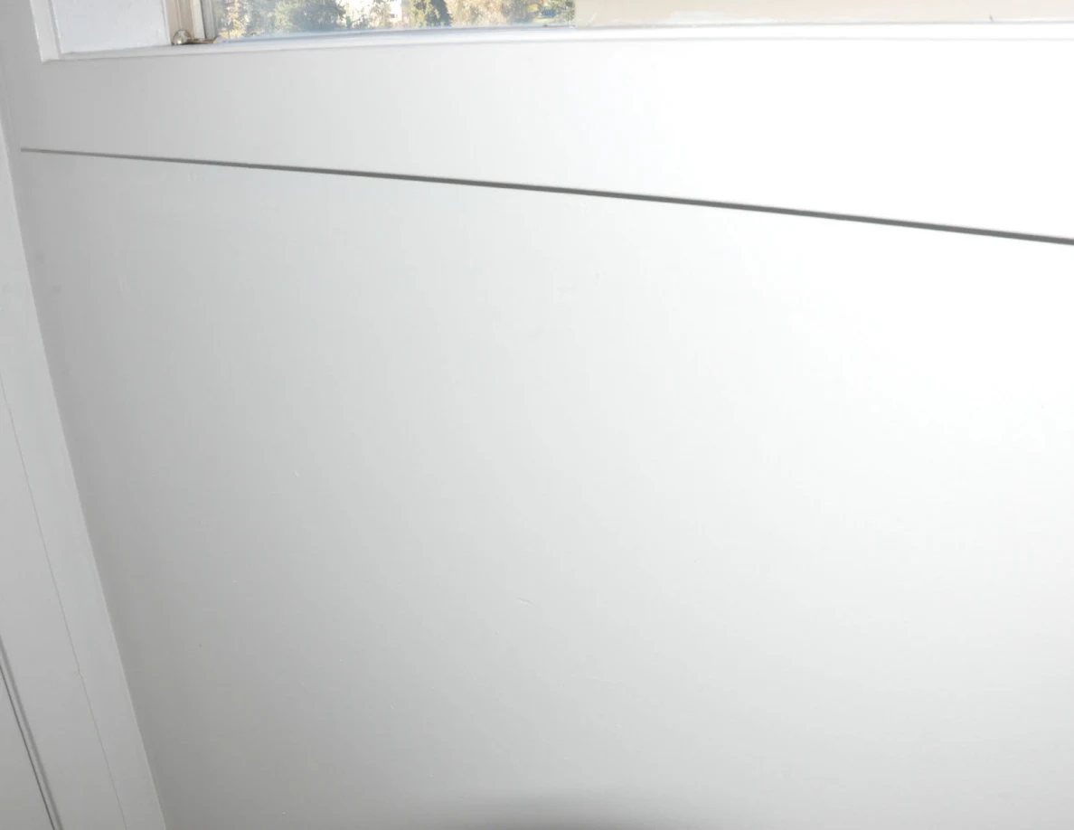 Plain white wall panel beneath a bathroom window.
