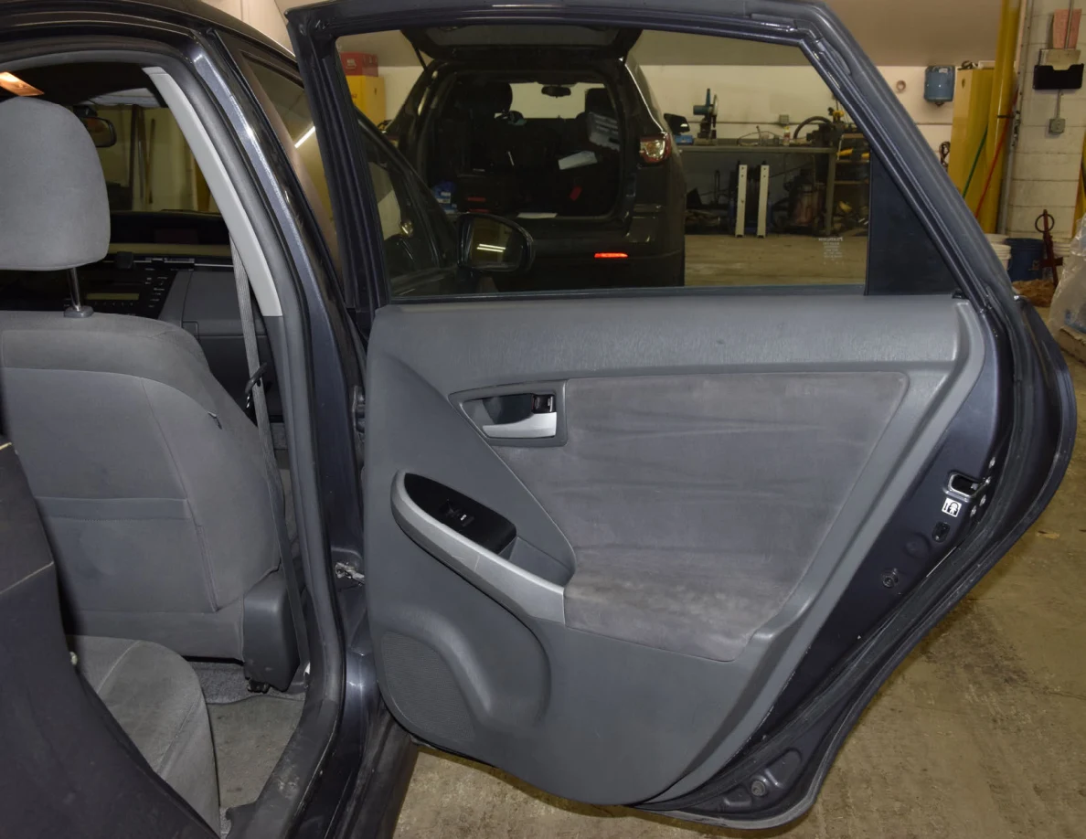 Open rear passenger door showing gray trim, silver handle and a rear seat.