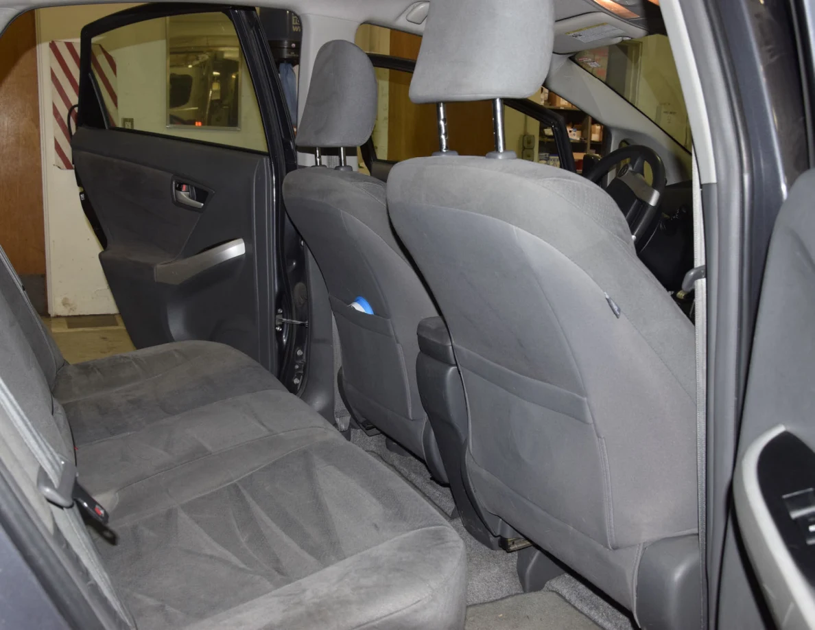 Rear bench and front-seat backs viewed through an open rear passenger door.