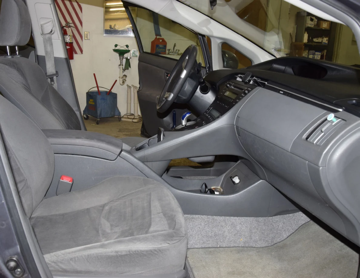 Front passenger seating area with gray fabric seat, dashboard, center console and floor mat.