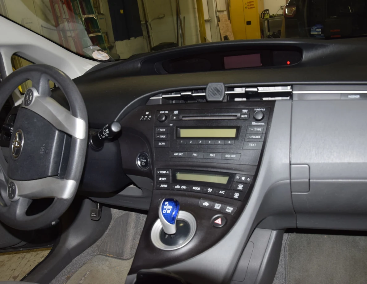Dashboard audio controls, blue gear selector and steering wheel in a Toyota interior.