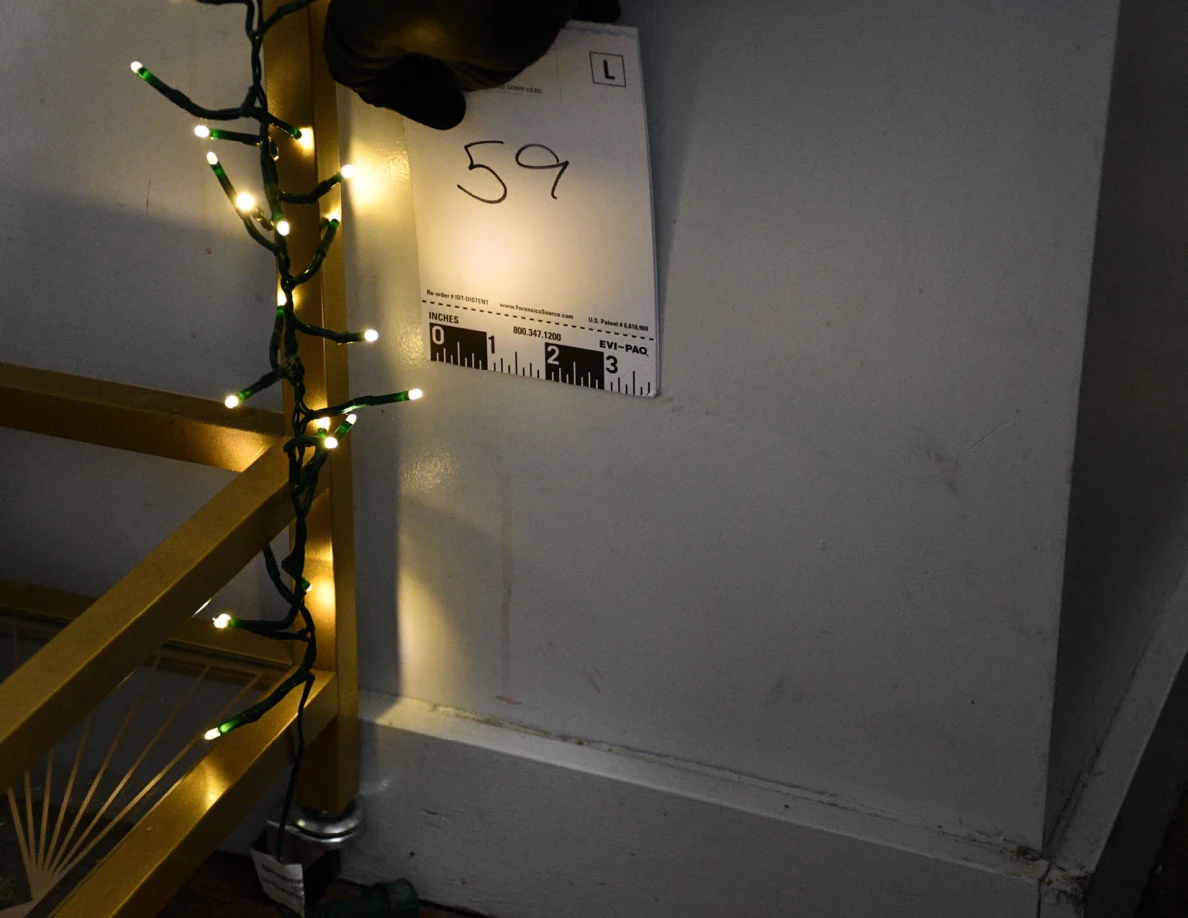 Card 59 held against the wall beside a gold serving cart wrapped in string lights.