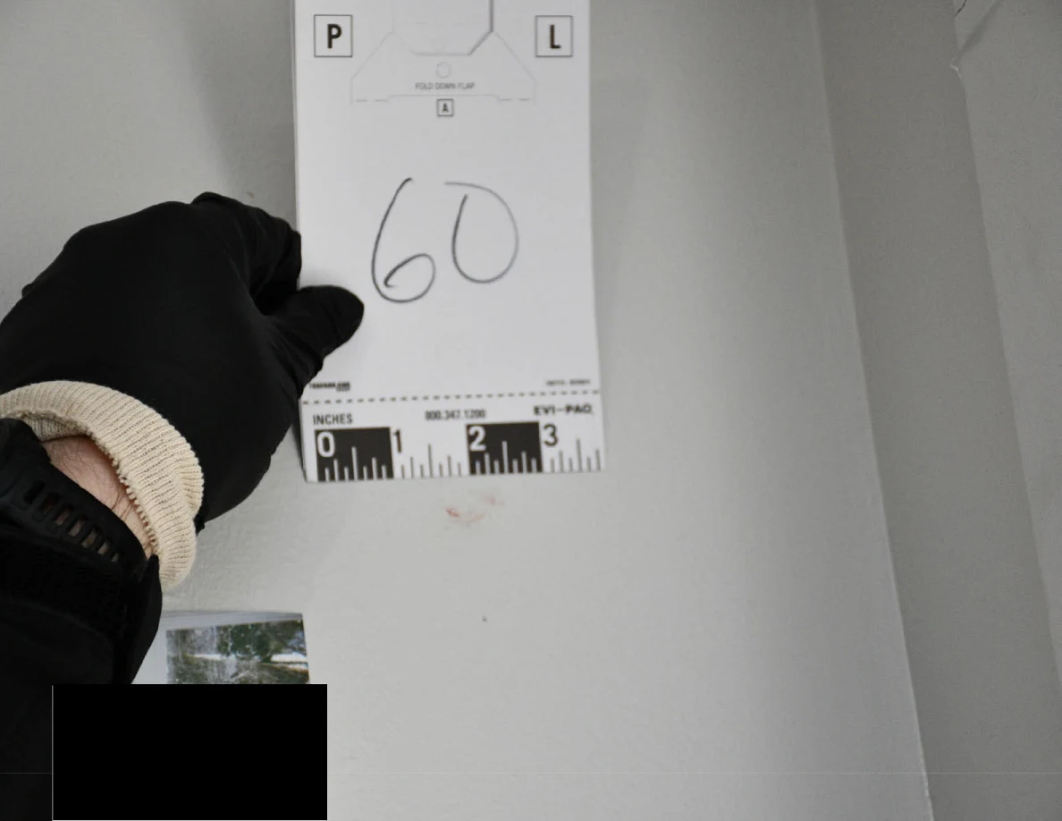 Card 60 held against a pale wall above a partly blacked-out photograph.