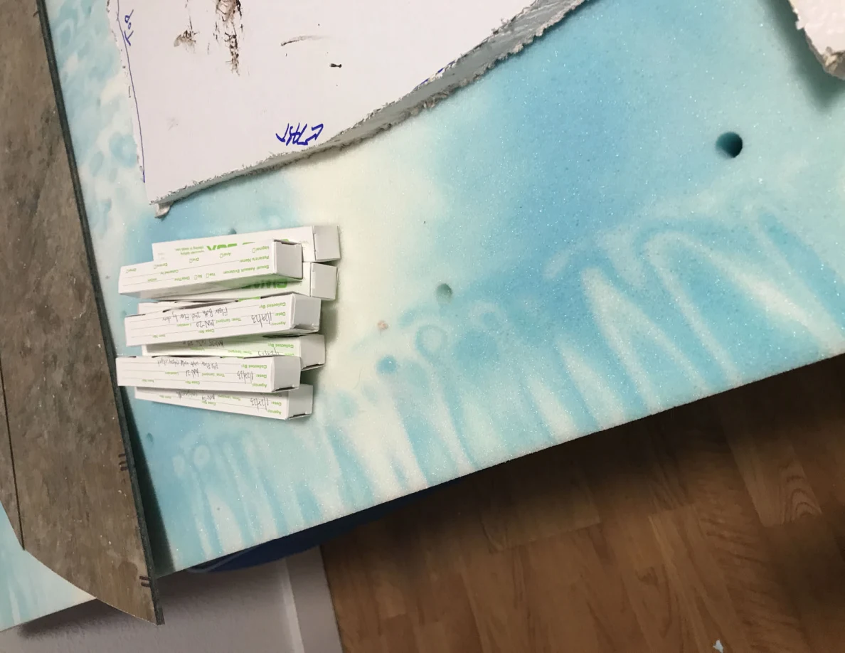 Small narrow labeled boxes beside the edge of a white panel cutout on a blue patterned surface.