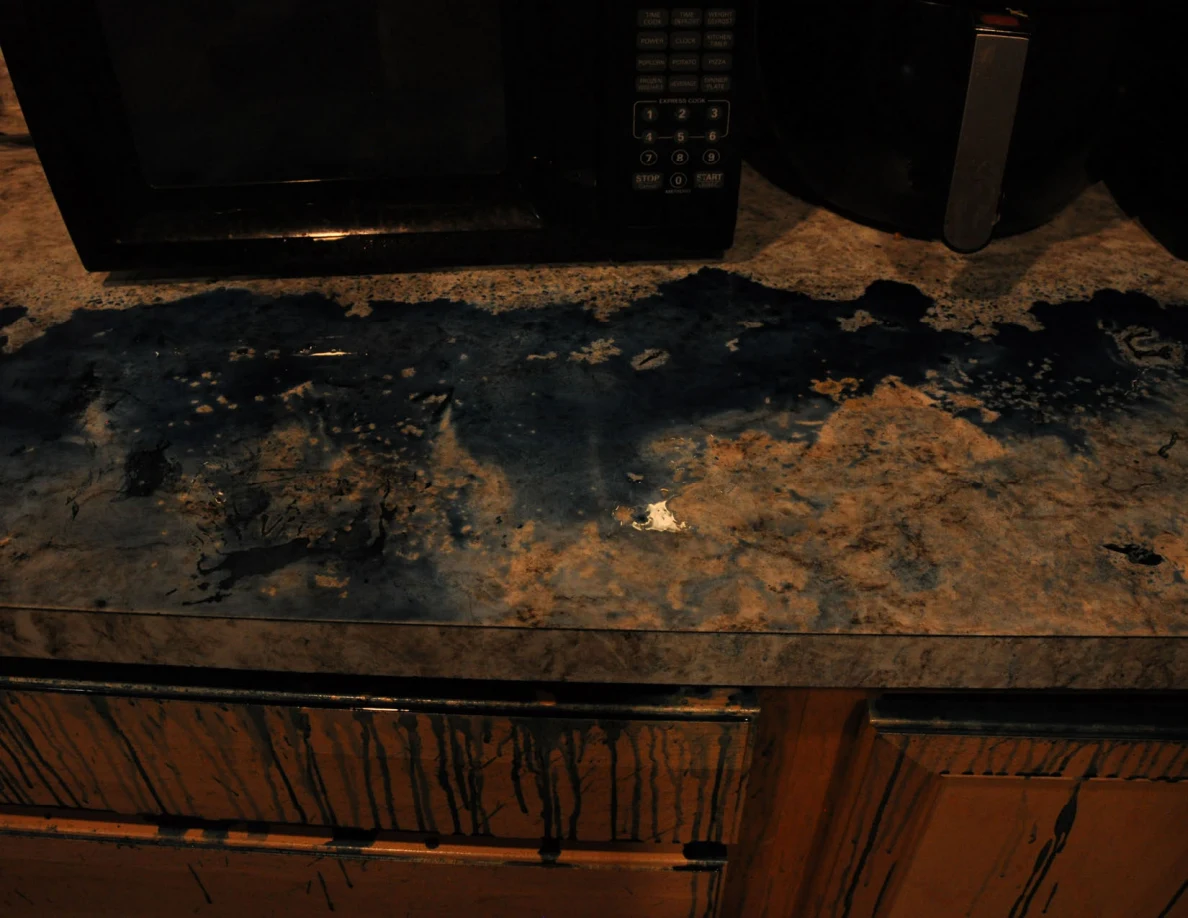Dim view of blue-covered countertop beneath a microwave and air fryer.