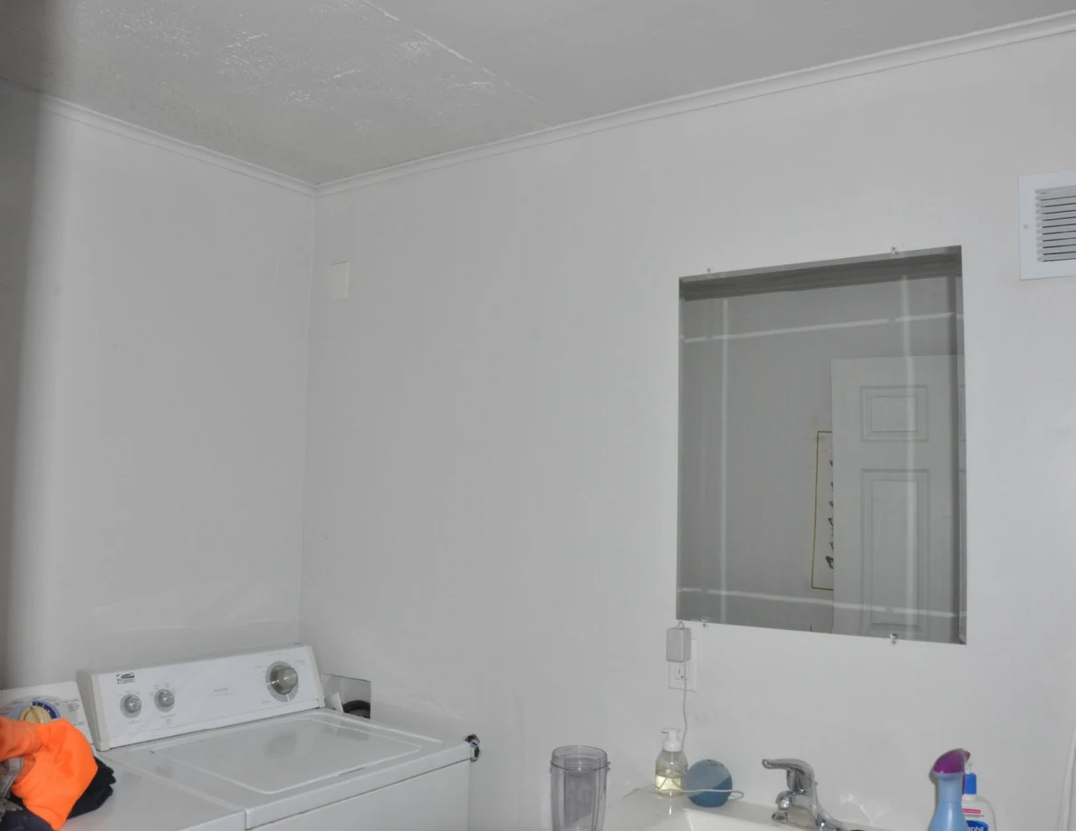 Laundry-room upper wall, ceiling and mirror above washer and sink.
