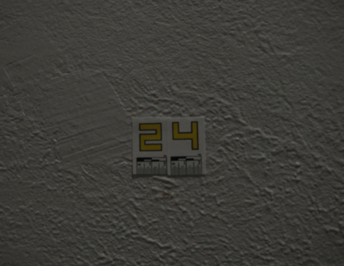 Dim close view of label 24 and faint wall marks.