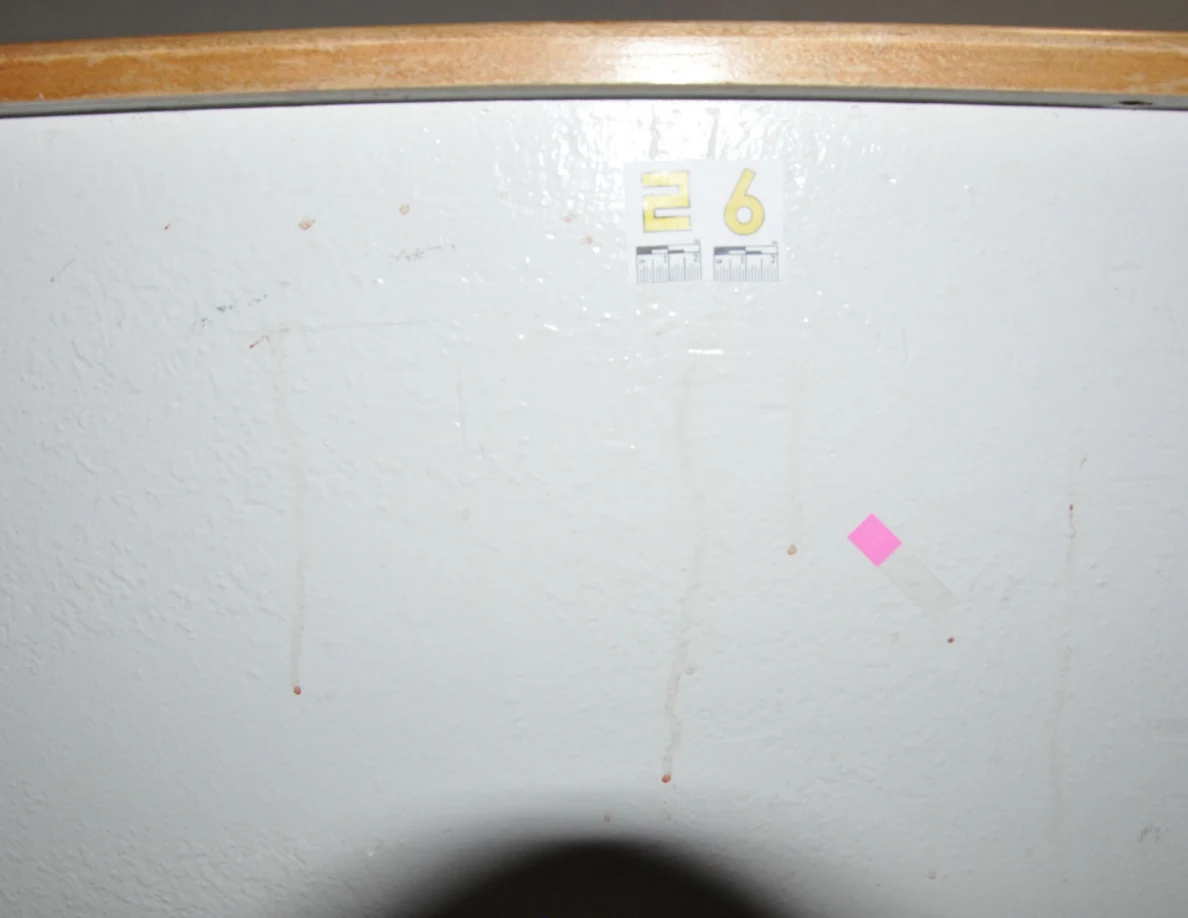 Bright view of label 26, pink tape and thin reddish streaks on a half-wall.