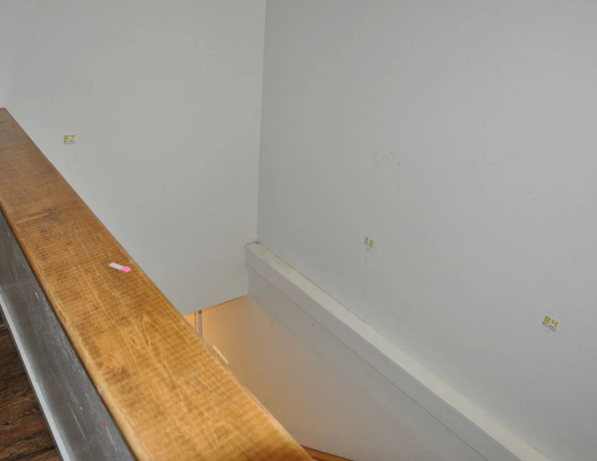 Stairwell corner with labels 23, 24 and 27 beside a wood-capped half-wall.