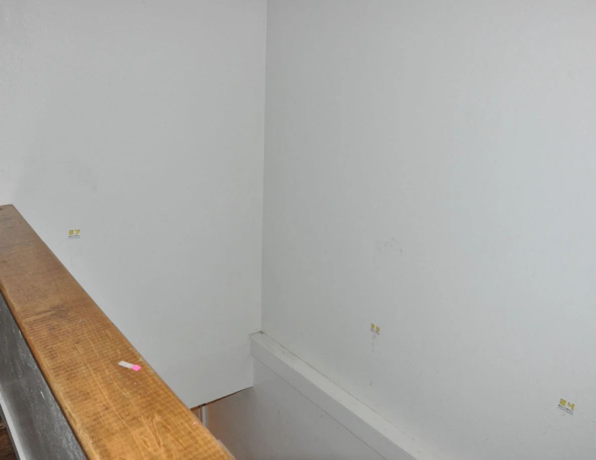 Wider view of labeled stairwell walls and wooden half-wall cap.