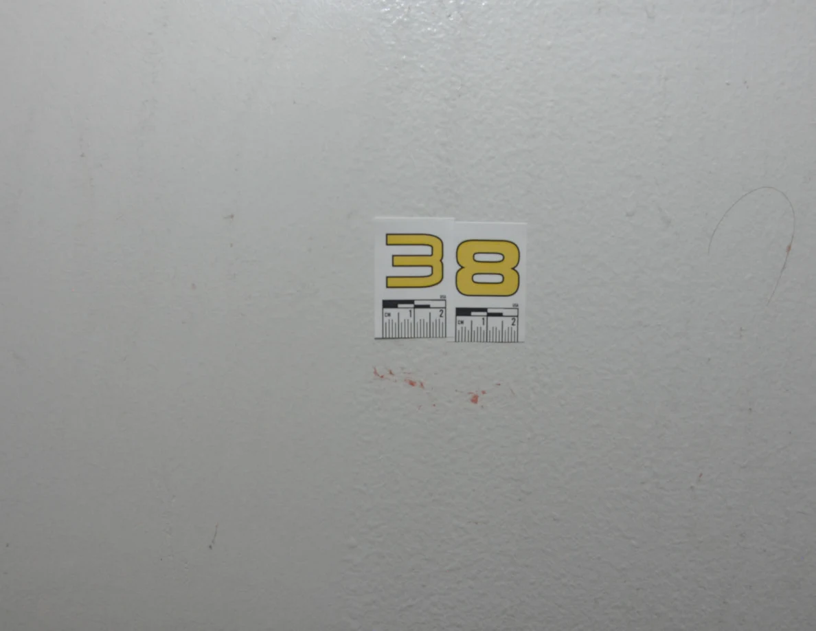 Yellow label 38 above a short reddish mark on a pale wall.