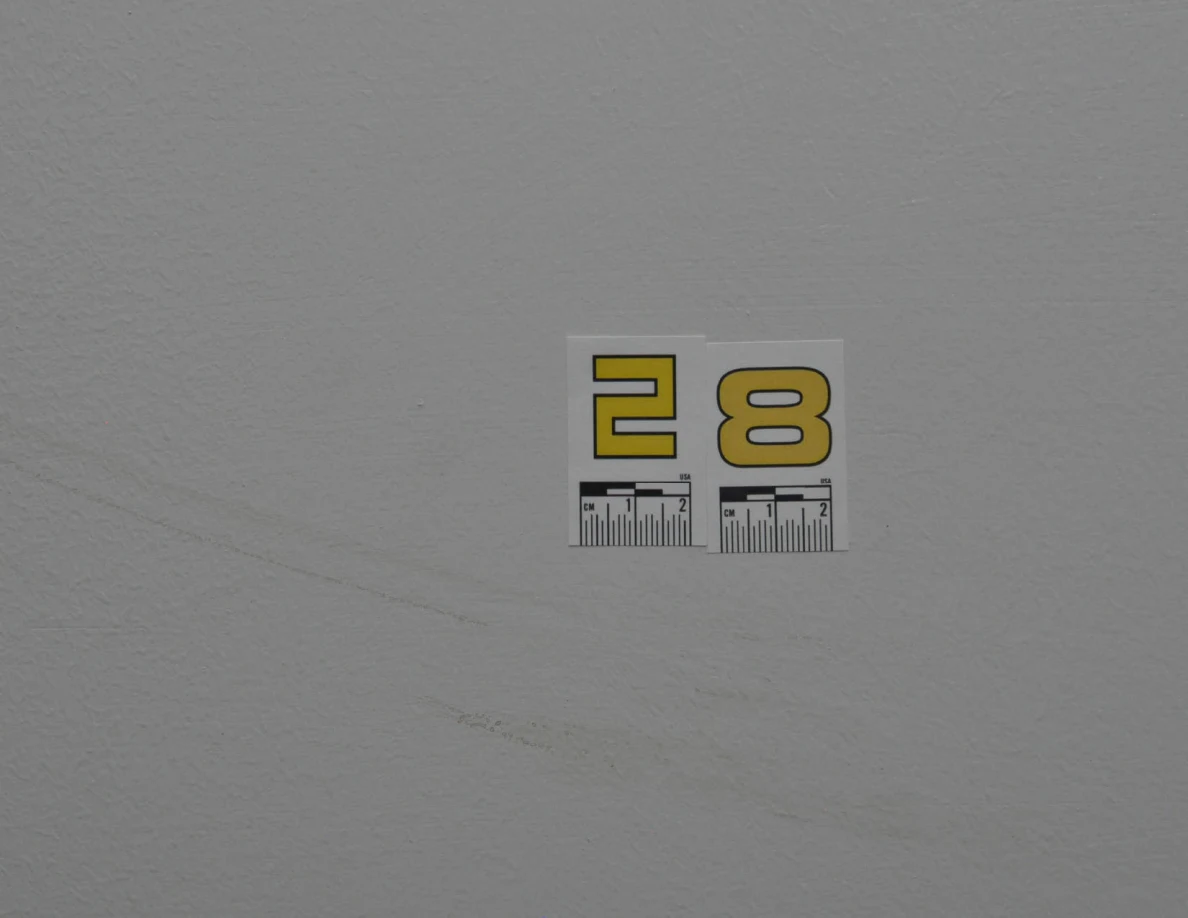Close view of label 28 and a faint diagonal curved wall scuff.