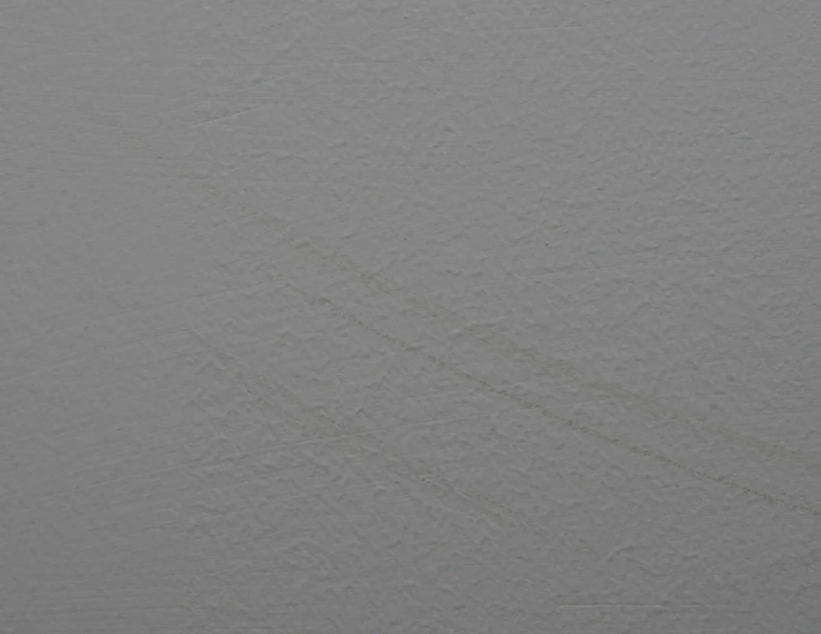 Close view of a long faint curved scuff on textured paint.