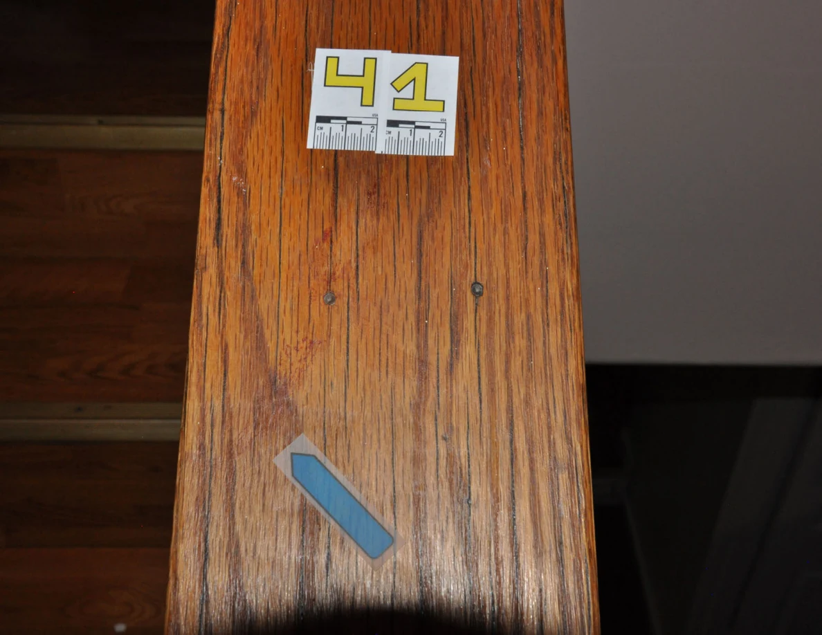 Dimmer view of label 41 and blue arrow on a wooden stair cap.