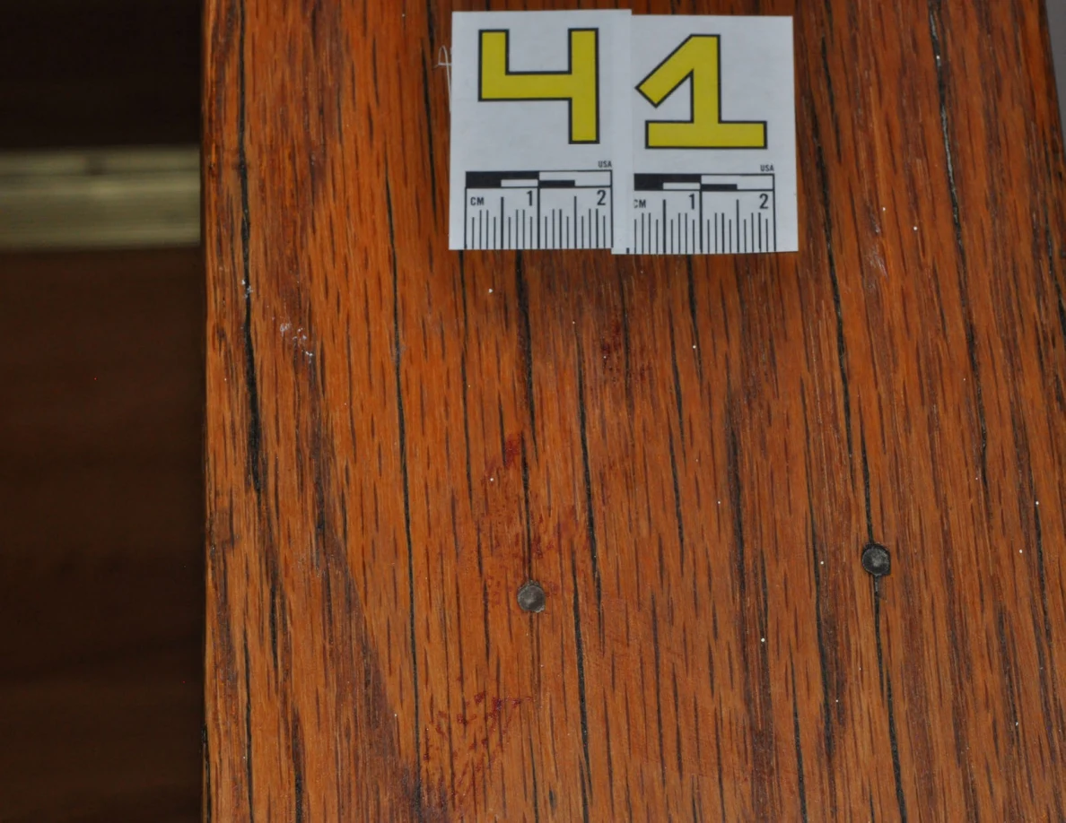 Close view of label 41 above reddish marks and two screw heads in a wooden cap.