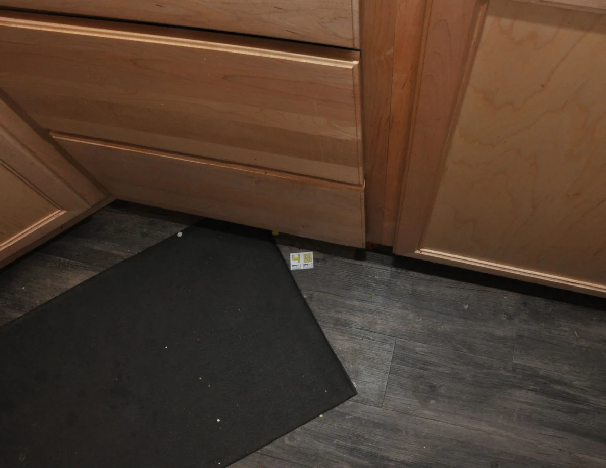Kitchen floor and dark mat beneath wooden drawers, with small yellow label 40.