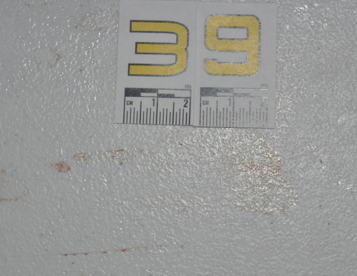 Close view of label 39 above reddish marks on a pale surface.