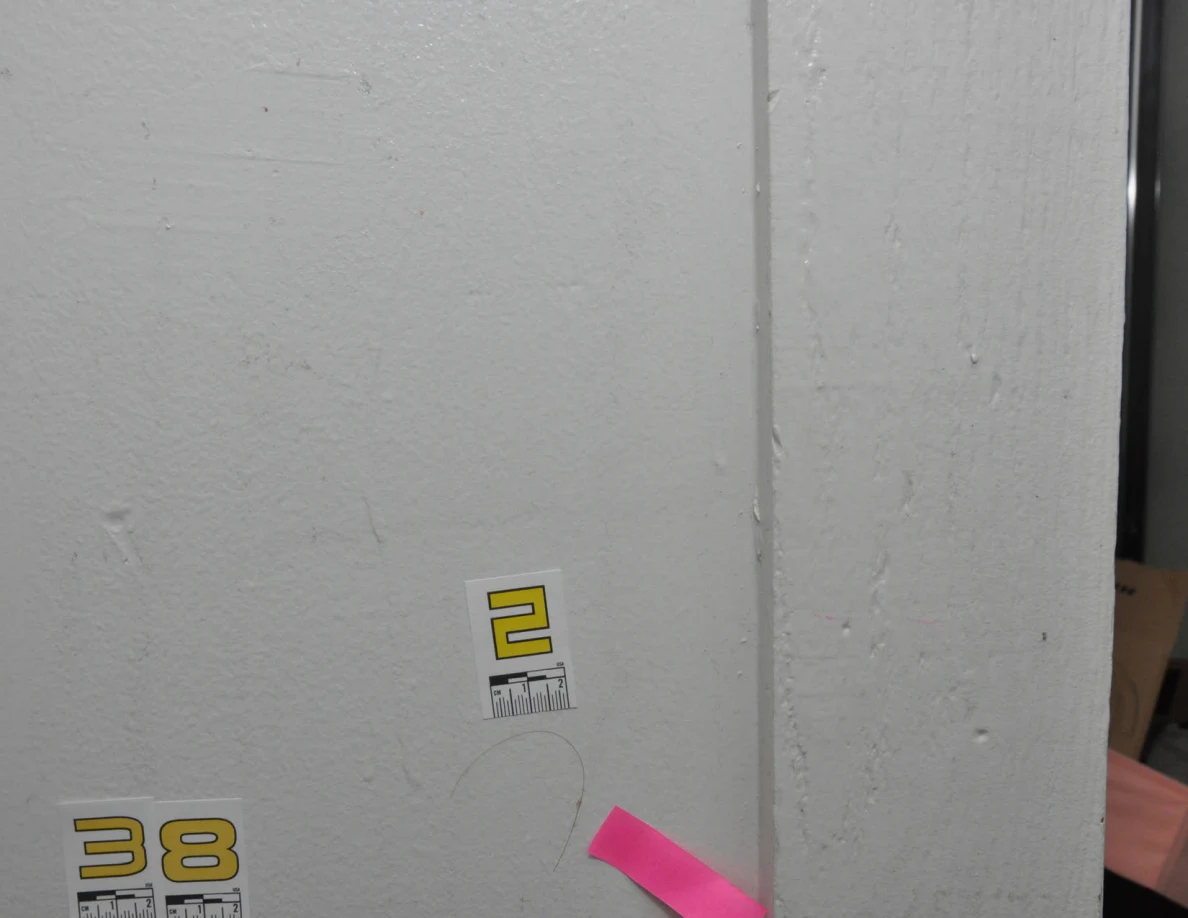 Closer view of label 2 above a curved strand on wall beside pink tape and label 38.