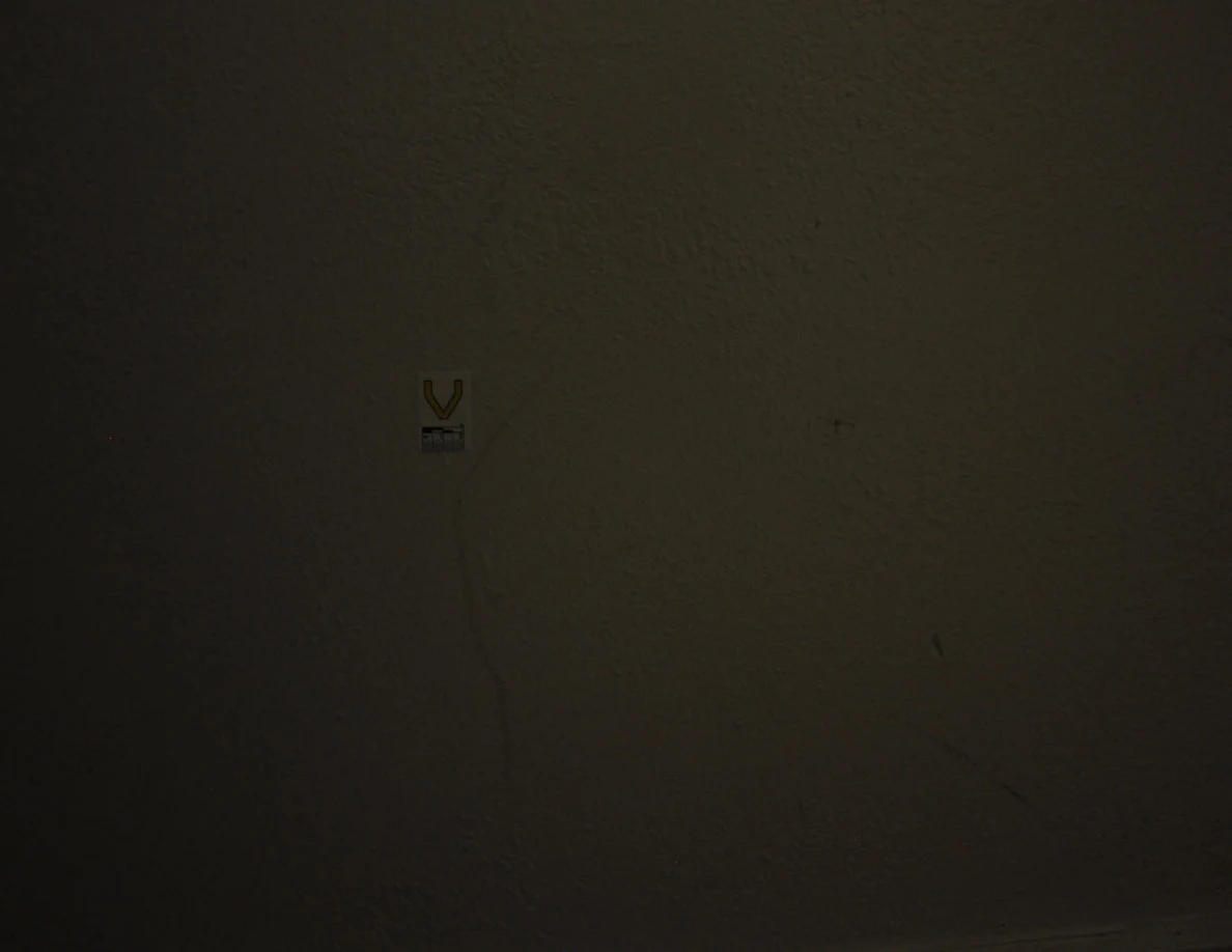 Dim view of label V and a faint vertical wall streak.