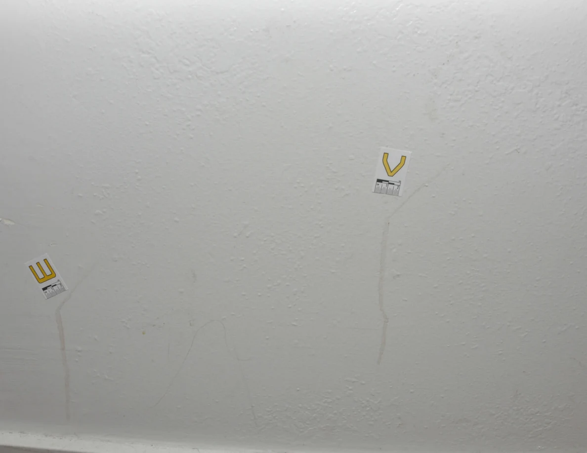 Labels W and V beside two faint wall streaks.