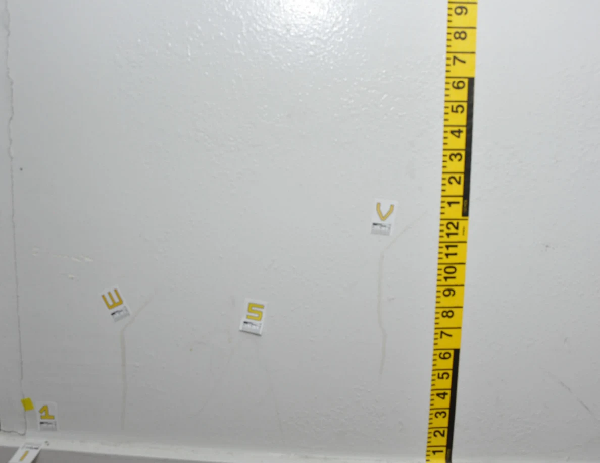 Wall labels W, S and V between a crack and vertical yellow measurement tape.