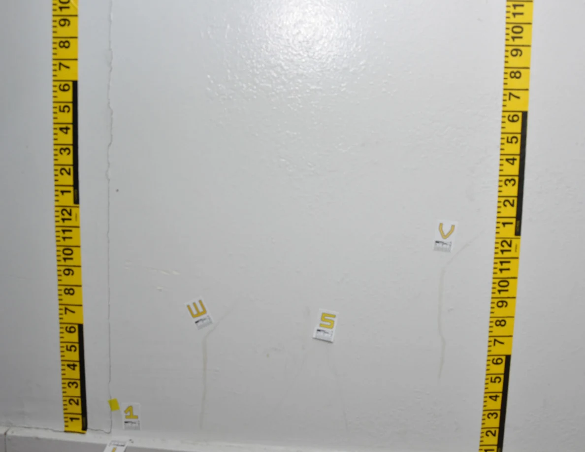 Wider wall area outlined by yellow measurement tape with labels beside faint marks.