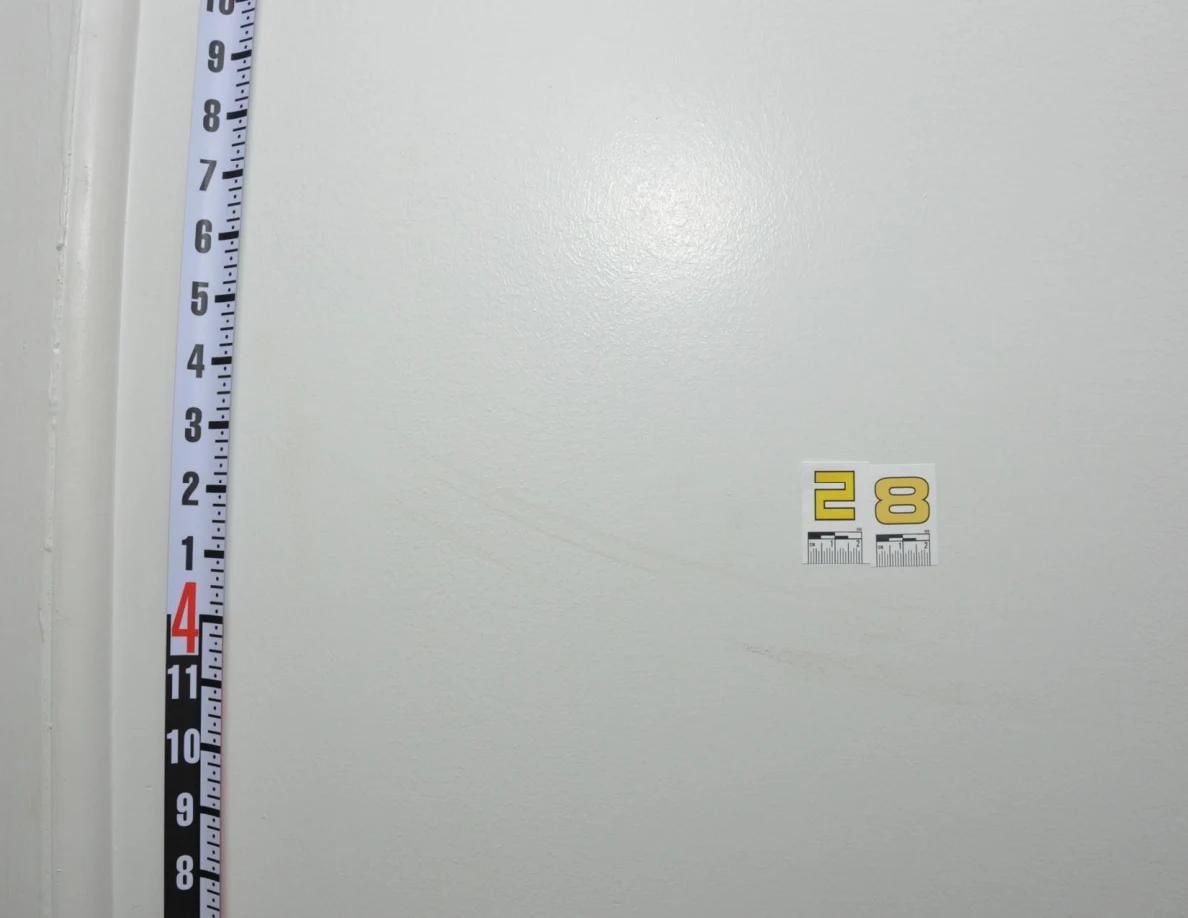 Label 28 beside a vertical measuring rod and faint curved wall scuff.