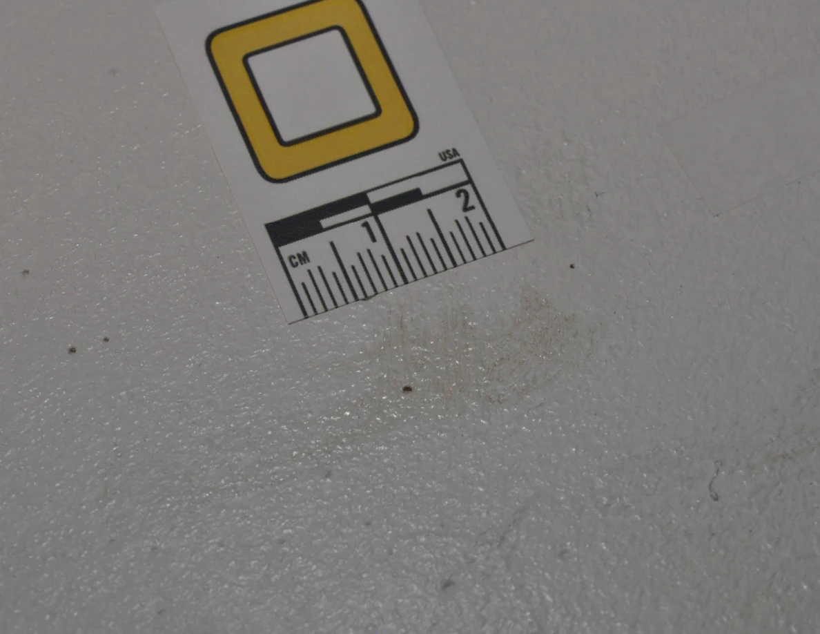 Closer view of letter O beside a faint brownish wall patch.