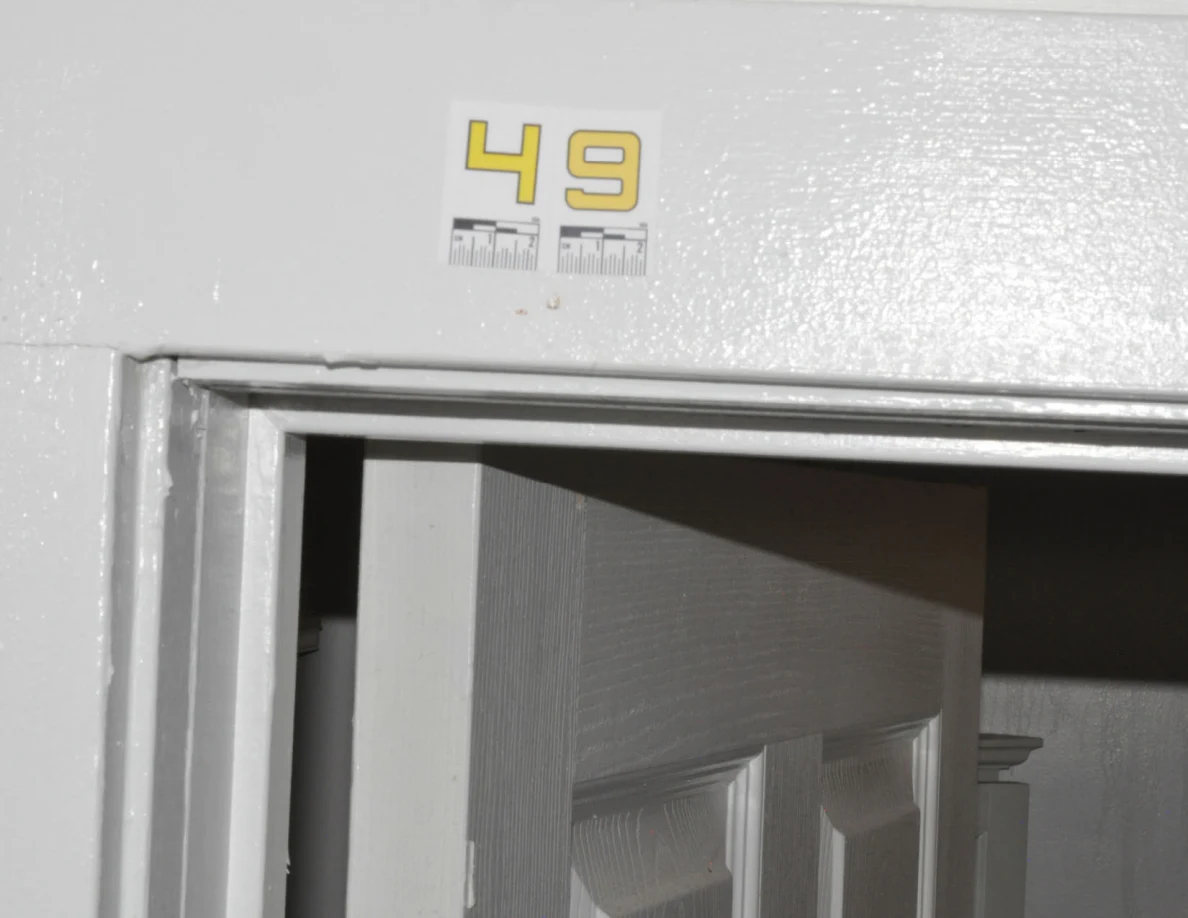 Label 49 above an open paneled door in a white frame.