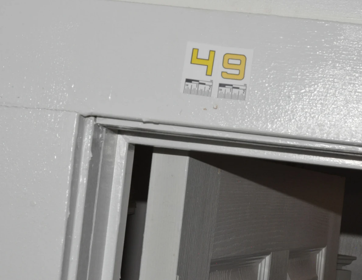 Close view of label 49 on glossy white doorway trim.