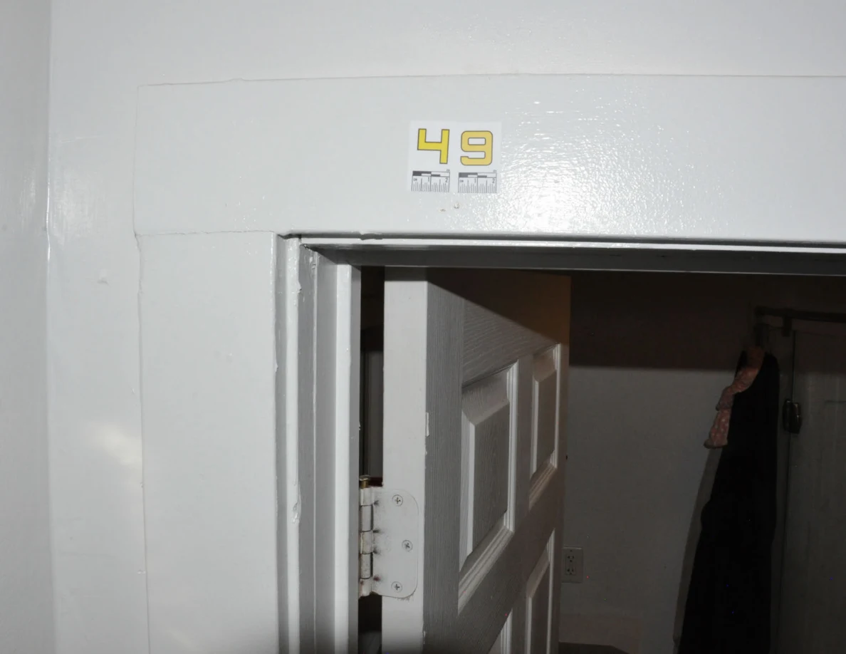Wider white bathroom door frame with label 49 and an open paneled door.
