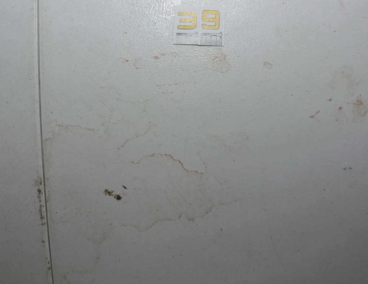Closer view of label 39 and irregular brownish ring marks on a white tabletop.