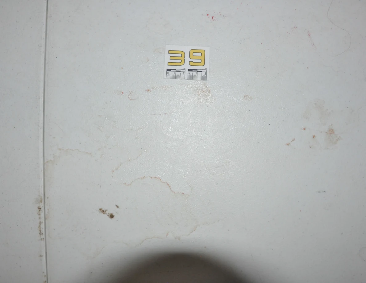Brighter view of label 39 and overlapping ring marks beside a seam in a white tabletop.