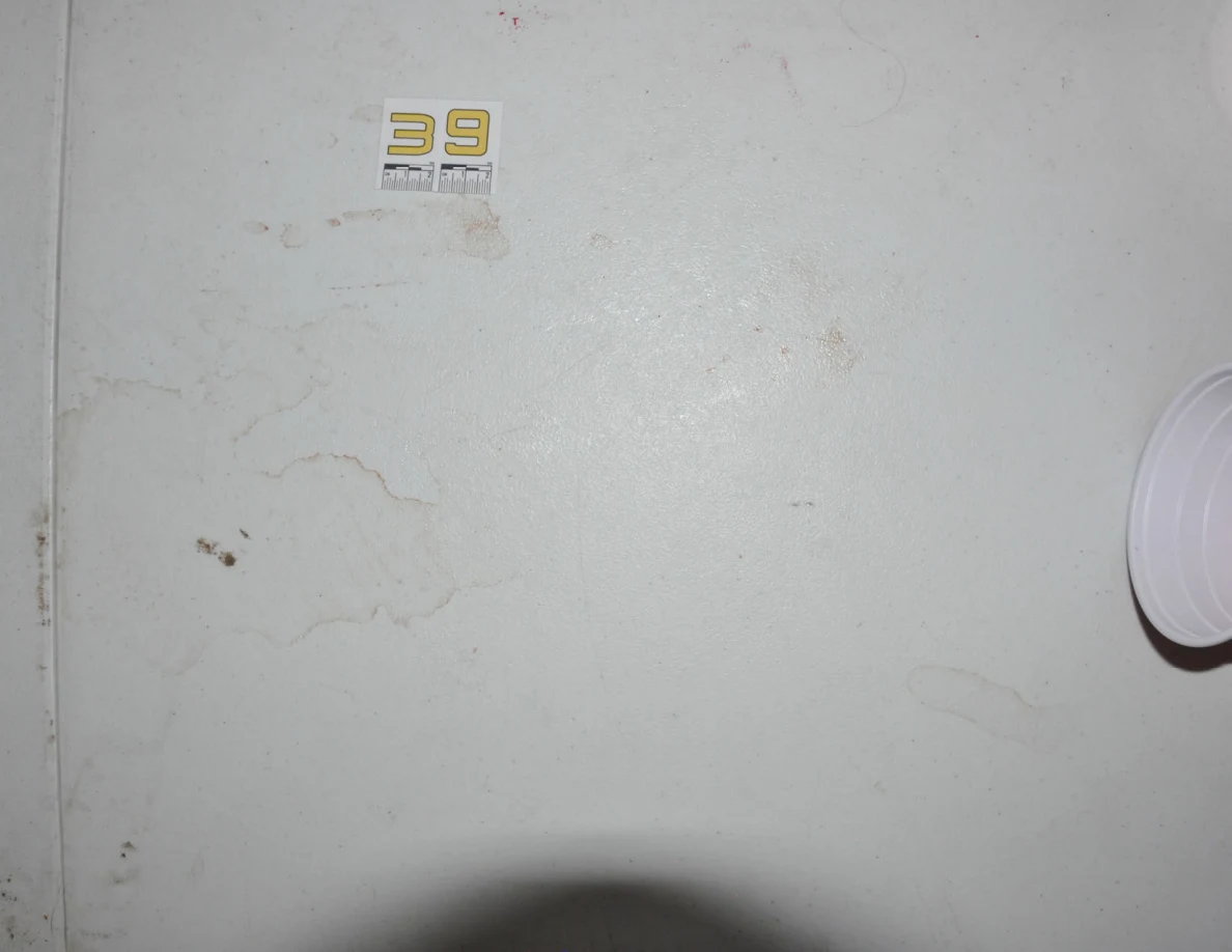 White tabletop with label 39, faint rings and the edge of a red plastic cup.