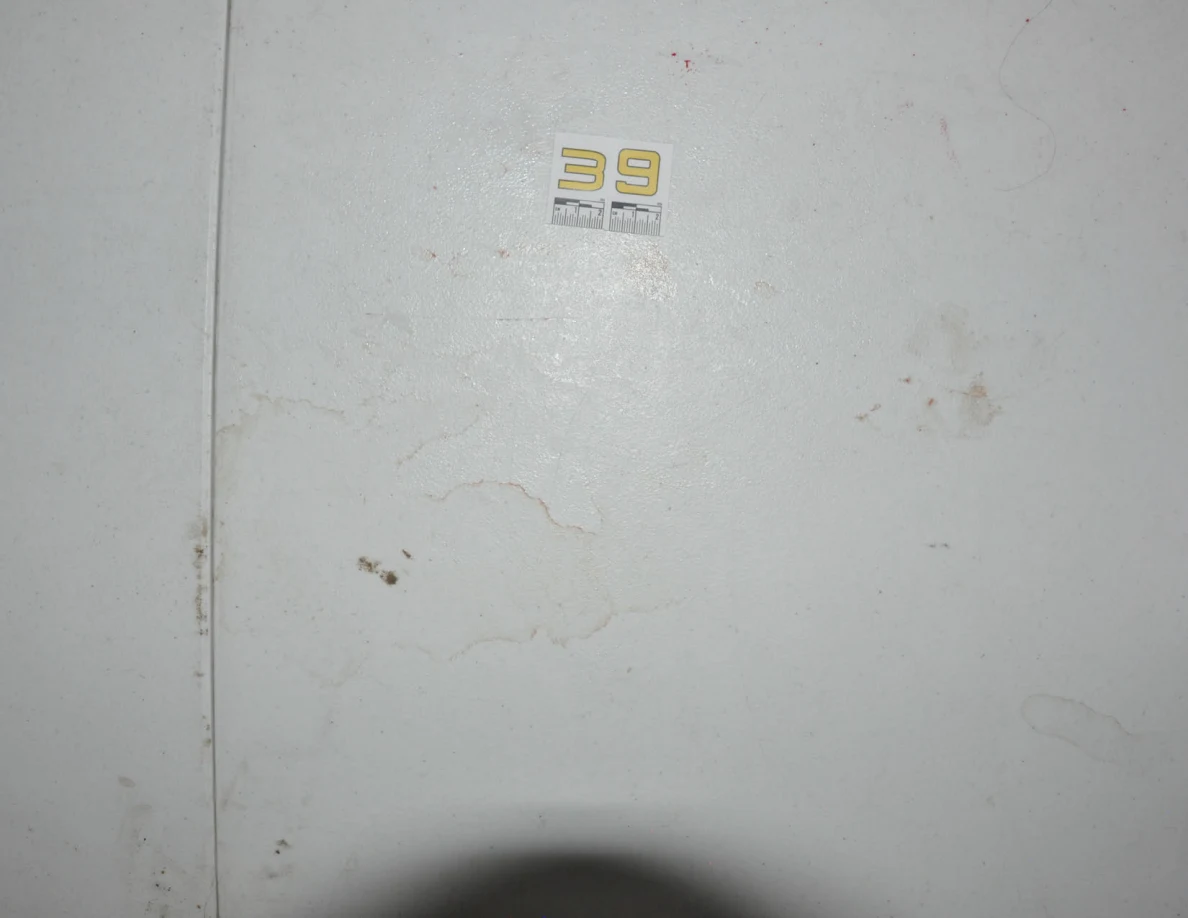 Label 39 above faint rings and smears on a white tabletop.