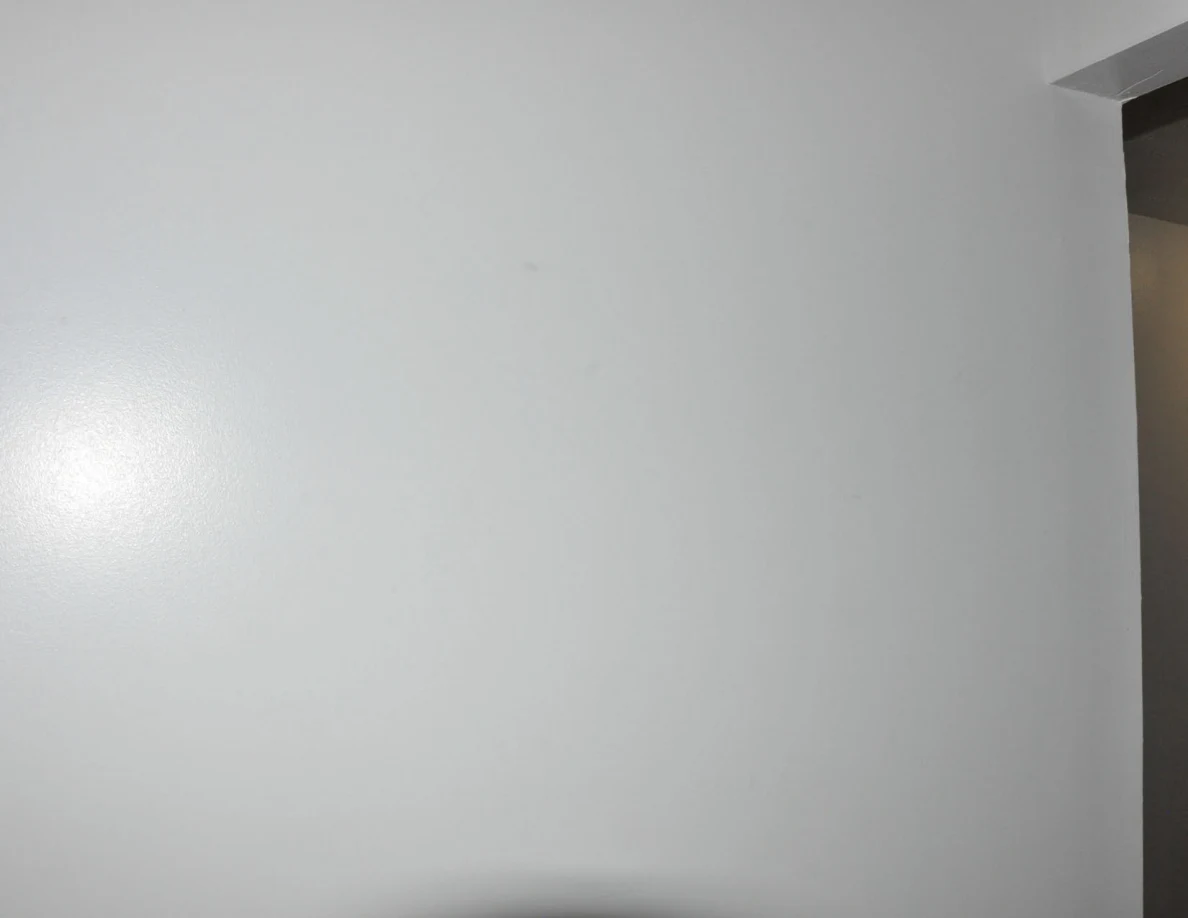 Plain white wall beside the upper corner of a stairwell opening.