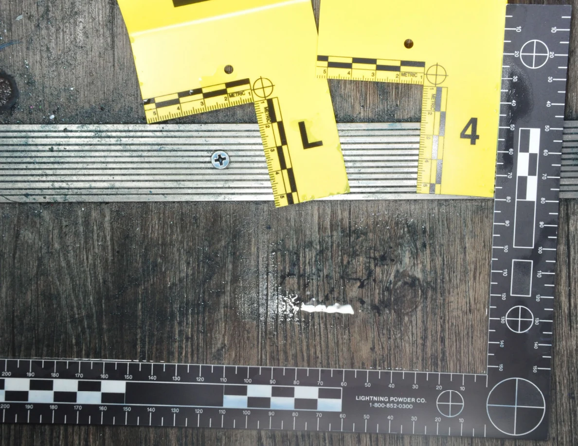 Bright reflective patch across dark floor marks below threshold markers L and 4.