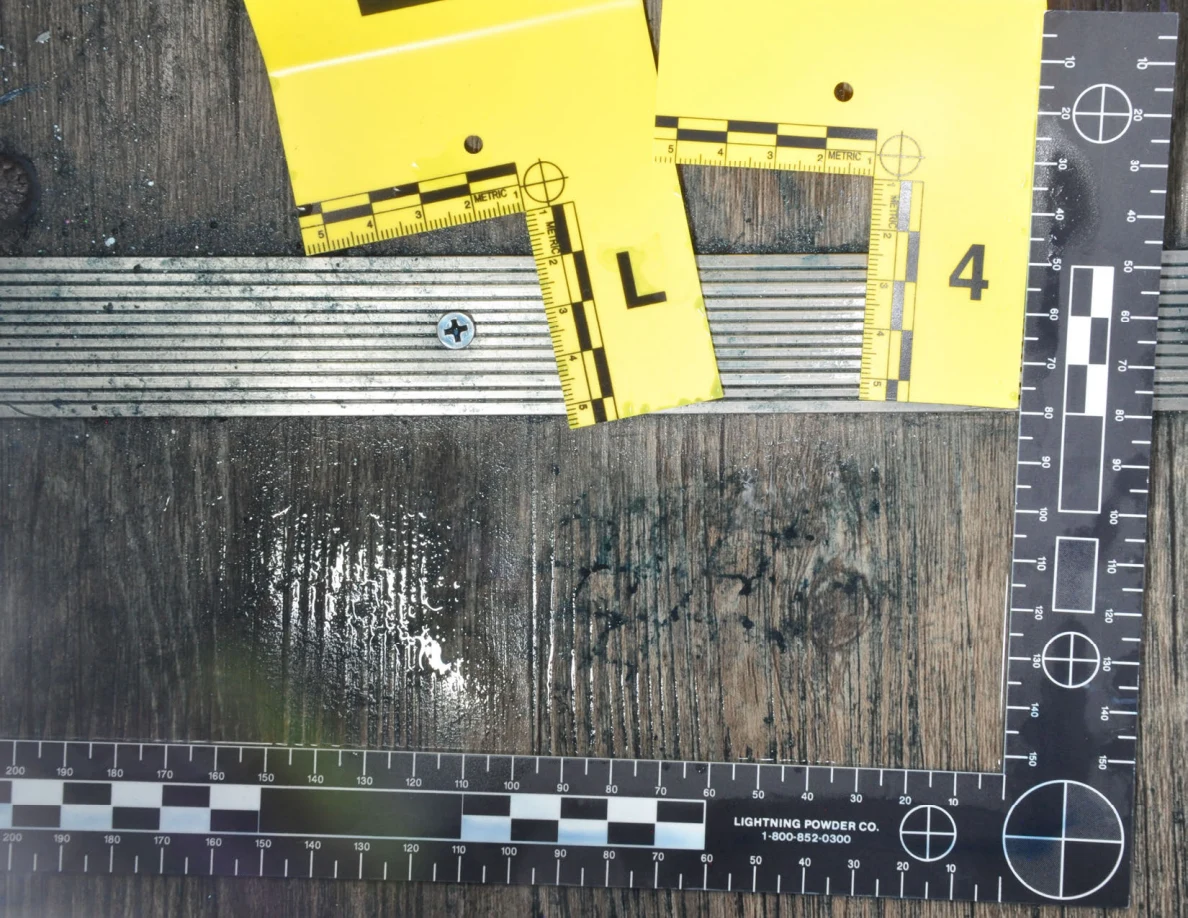 Reflective patch beside dark floor marks below yellow L and 4 scales at a threshold.