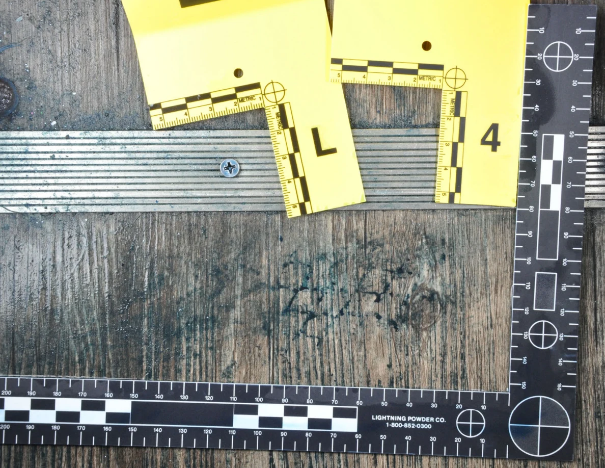 Measured floor area with dark marks beneath a ridged metal threshold.