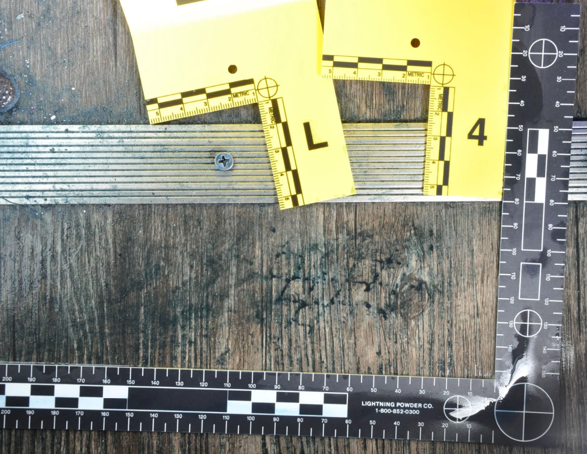 Angled measured view of dark floor marks beneath yellow threshold markers.