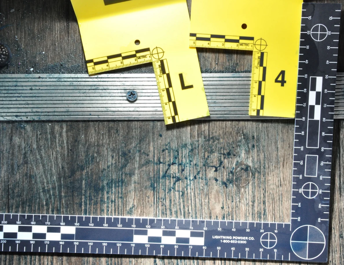 Lower angle of dark floor marks beneath a metal threshold and yellow scales.