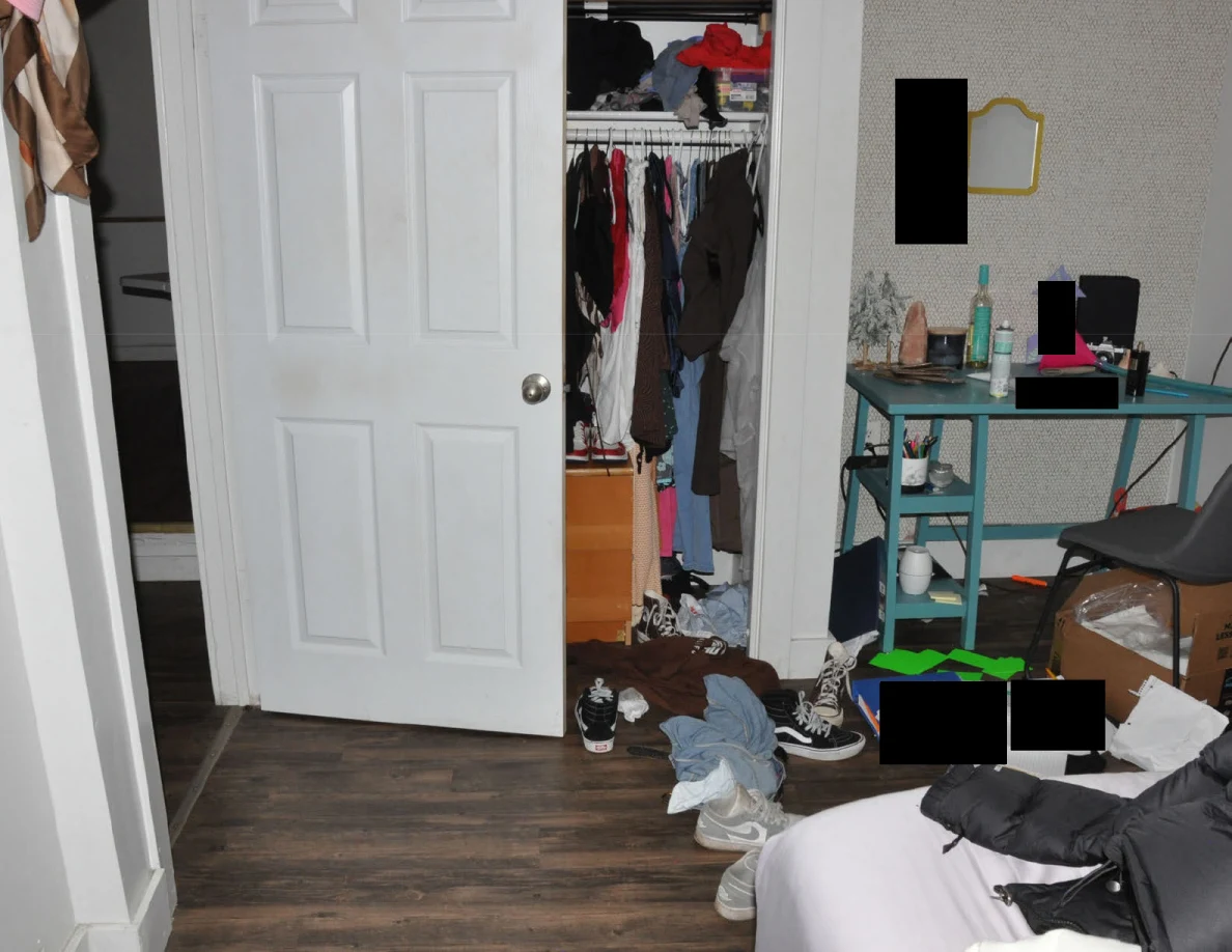 Bedroom facing an open closet and turquoise desk with scattered shoes, clothes and redacted papers.