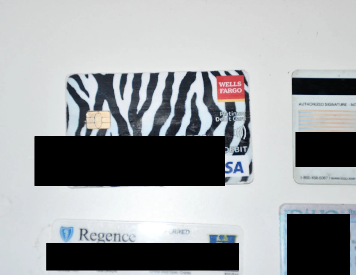 Close view of a zebra-pattern bank card beside other redacted cards.